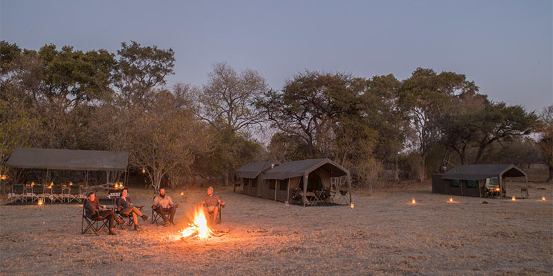 Guests relaxing around a fire on a mobile safari in Botswana Botswana mobile safari